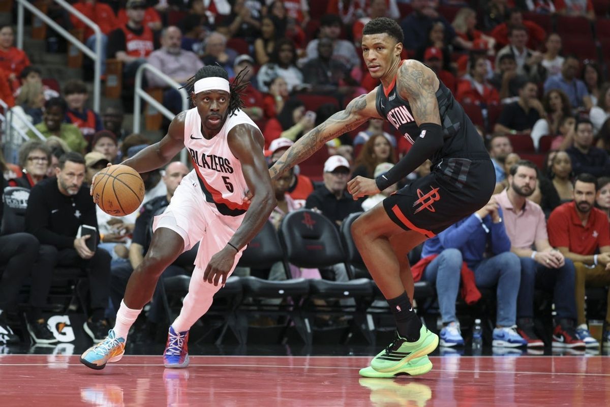Nov 14, 2025; Houston, Texas, USA;  Portland Trail Blazers guard Jrue Holiday (5) dribbles the ball as Houston Rockets forward Jabari Smith Jr. (10) defneds during the third quarter at Toyota Center. Mandatory Credit: Troy Taormina-Imagn Images