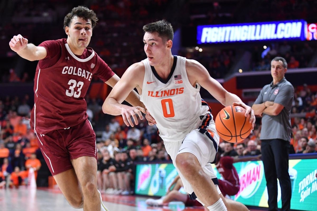 Nov 14, 2025; Champaign, Illinois, USA;  Illinois Fighting Illini forward David Mirkovic (0) drives the ball against Colgate Raiders forward Sam Wright (33) during the first half at State Farm Center. Mandatory Credit: Ron Johnson-Imagn Images