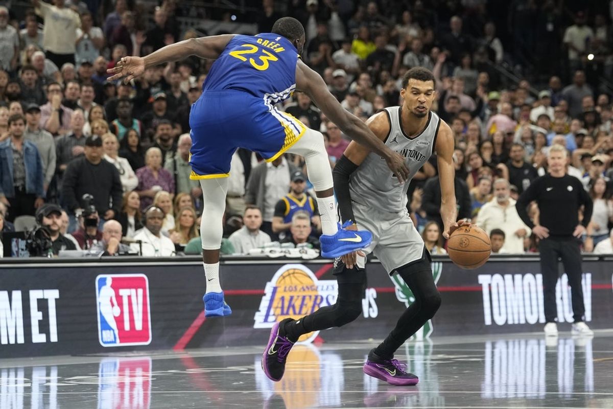 Nov 14, 2025; San Antonio, Texas, USA; San Antonio Spurs forward Victor Wembanyama (1) dribbles while defended by Golden State Warriors forward Draymond Green (23) during the second half against the Golden State Warriors at Frost Bank Center. Mandatory Credit: Scott Wachter-Imagn Images