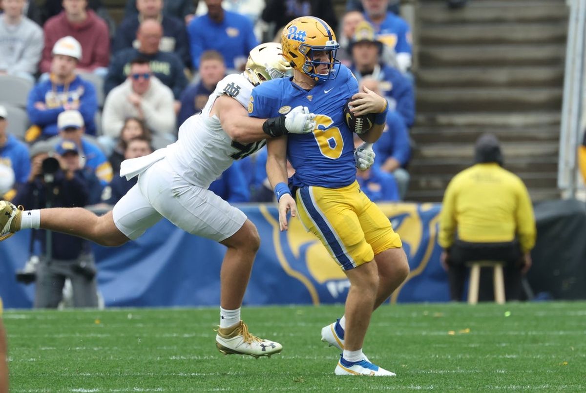 Nov 15, 2025; Pittsburgh, Pennsylvania, USA;  Notre Dame Fighting Irish defensive lineman Joshua Burnham (left) tackles Pittsburgh Panthers quarterback Mason Heintschel (6) during the first quarter at Acrisure Stadium. Mandatory Credit: Charles LeClaire-Imagn Images