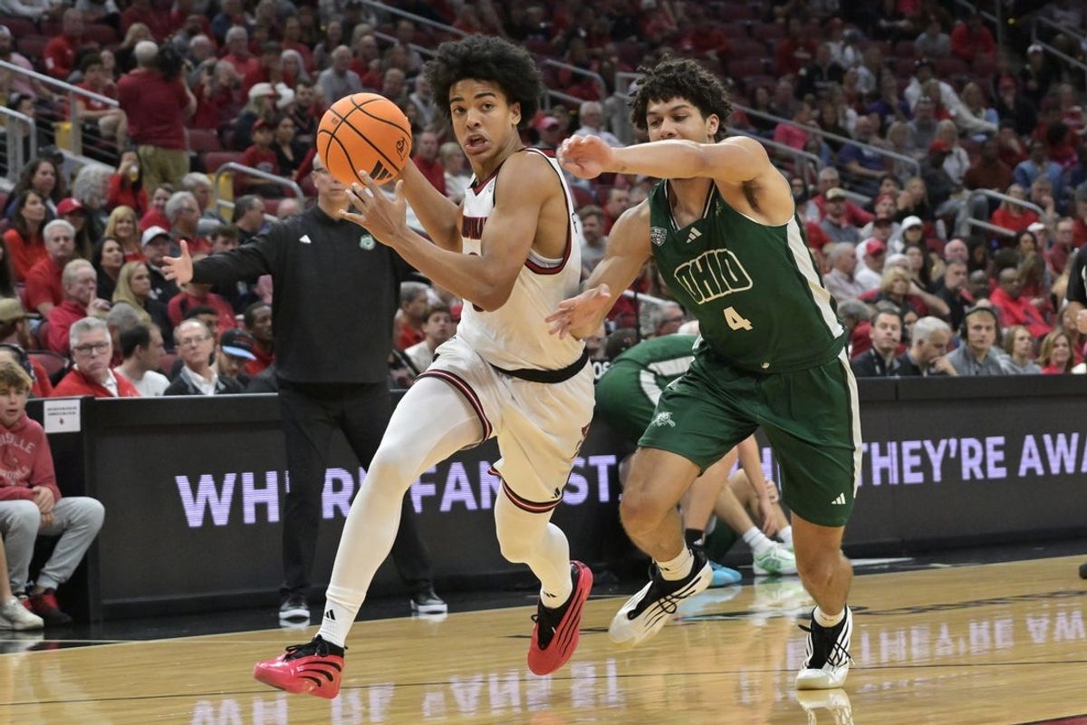 Nov 15, 2025; Louisville, Kentucky, USA;  Louisville Cardinals guard Mikel Brown Jr. (0) drives to the basket against Ohio Bobcats guard JJ Kelly (4) during the first half at KFC Yum! Center. Mandatory Credit: Jamie Rhodes-Imagn Images