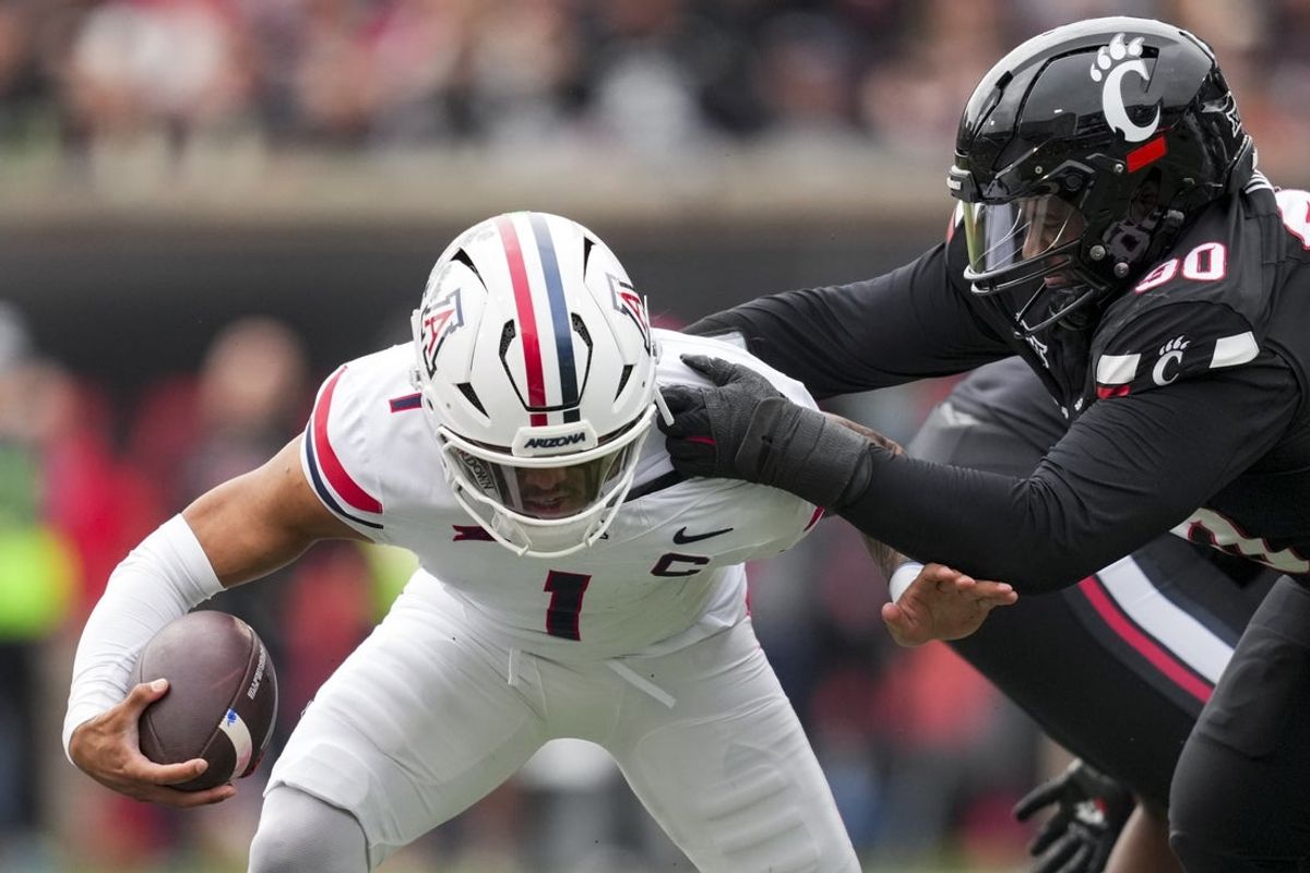 Nov 15, 2025; Cincinnati, Ohio, USA;  Arizona Wildcats quarterback Noah Fifita (1) is sacked by Cincinnati Bearcats defensive lineman Jalen Hunt (90) in the first half at Nippert Stadium. Mandatory Credit: Aaron Doster-Imagn Images