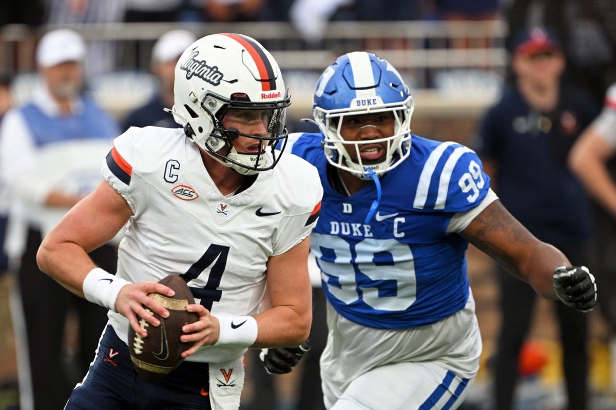 Nov 15, 2025; Durham, North Carolina, USA;  Virginia Cavaliers quarter back Chandler Morris (4) looks for an opening against Duke Blue Devils defensive tackle Aaron Hall (99) during the first quarter at Wallace Wade Stadium. Mandatory Credit: Zachary Taft-Imagn Images