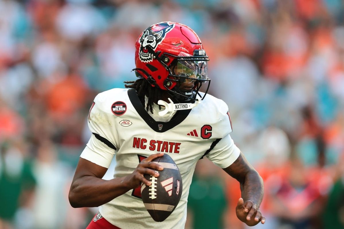 Nov 15, 2025; Miami Gardens, Florida, USA; NC State Wolfpack quarterback CJ Bailey (11) looks for a passing option against the Miami Hurricanes during the second quarter at Hard Rock Stadium. Mandatory Credit: Sam Navarro-Imagn Images