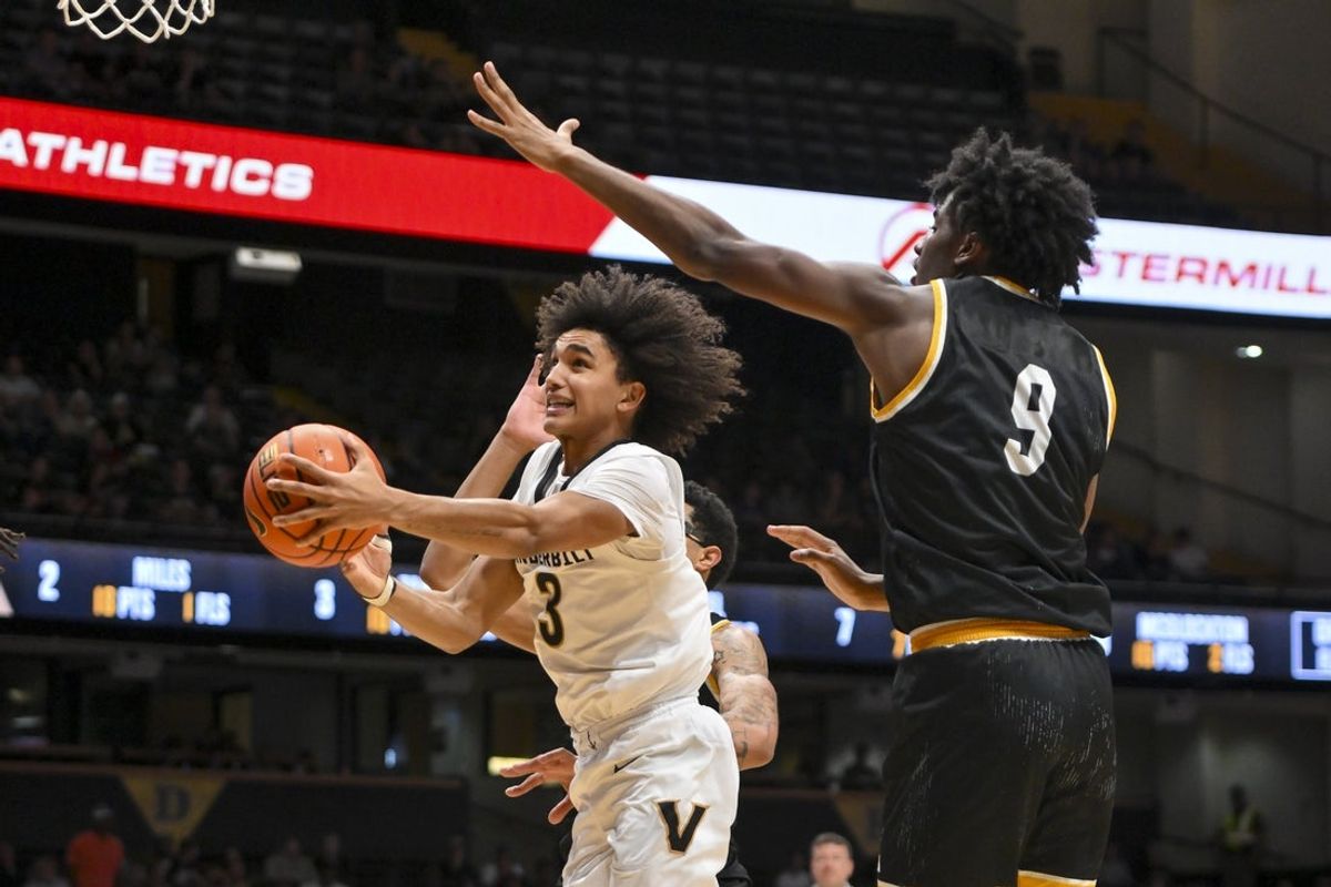 Nov 15, 2025; Nashville, Tennessee, USA;  Vanderbilt Commodores guard Tyler Tanner (3) shoots under the arm of Arkansas-Pine Bluff Golden Lions forward Milhan Charles (9) during the second half at Memorial Gymnasium. Mandatory Credit: Steve Roberts-Imagn Images