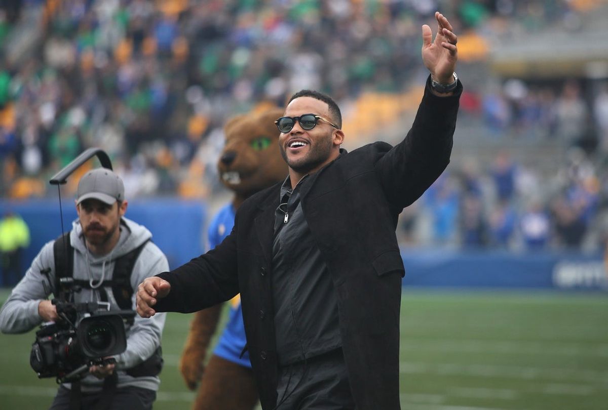 Former Pittsburgh Panther and retired NFL defensive tackle Aaron Donald waves to the crowd while walking out onto the field during his jersey number retirement ceremony during halftime of the Pittsburgh Panthers vs Notre Dame Fighting Irish game at Acrisure Stadium in Pittsburgh, PA on November 15, 2025.