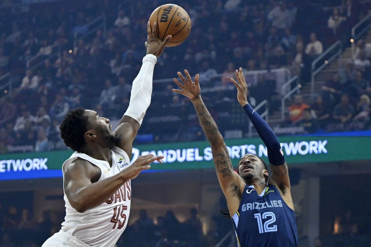 Nov 15, 2025; Cleveland, Ohio, USA; Cleveland Cavaliers guard Donovan Mitchell (45) defends a shot by Memphis Grizzlies guard Ja Morant (12) in the first quarter at Rocket Arena. Mandatory Credit: David Richard-Imagn Images
