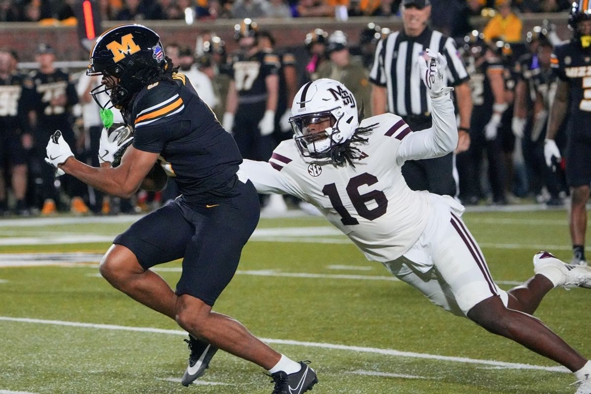 Nov 15, 2025; Columbia, Missouri, USA; Missouri Tigers wide receiver Joshua Manning (0) breaks a tackle attempt from Mississippi State Bulldogs linebacker Derion Gullette (16) and runs in for a touchdown during the first half of the game at Faurot Field at Memorial Stadium. Mandatory Credit: Denny Medley-Imagn Images