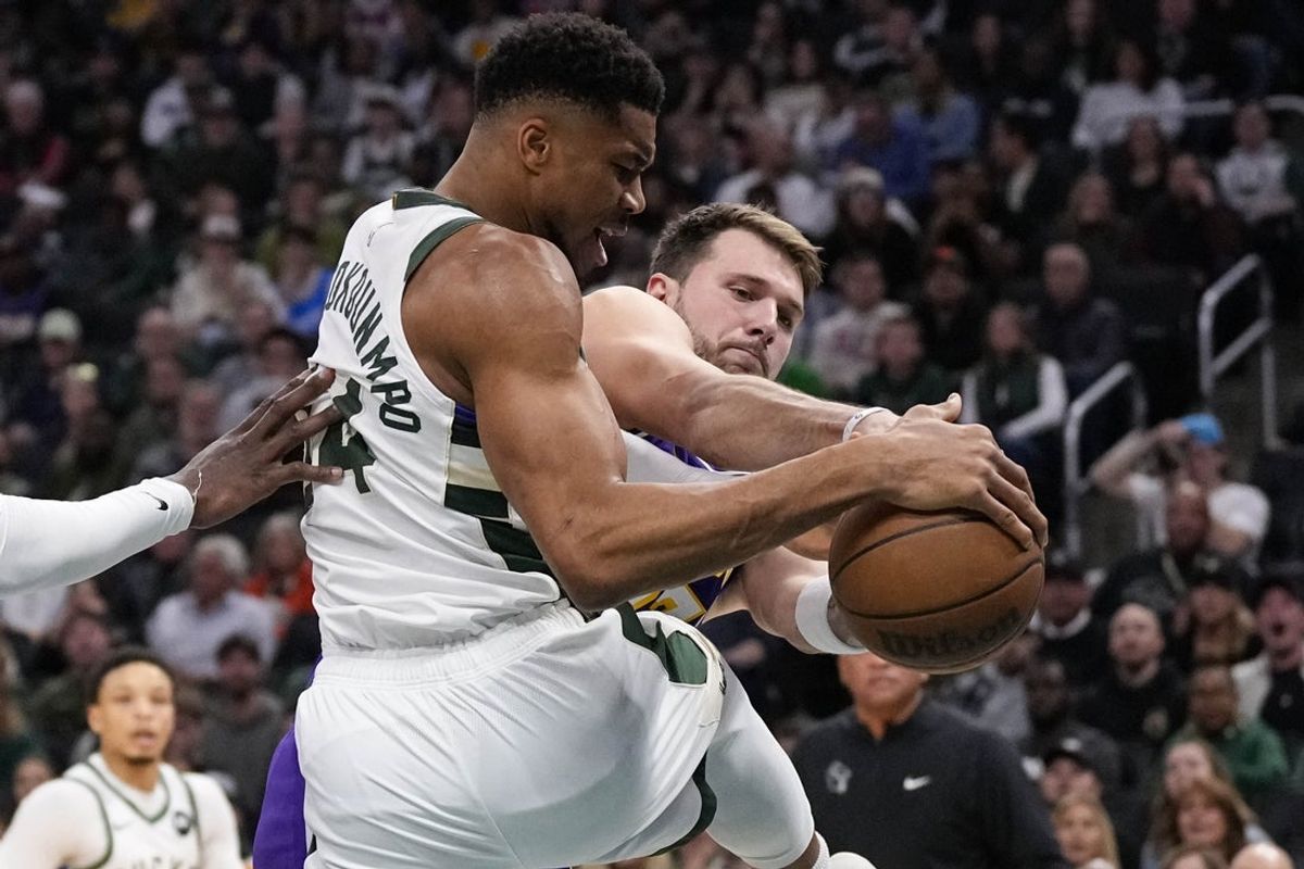 Nov 15, 2025; Milwaukee, Wisconsin, USA;  Milwaukee Bucks forward Giannis Antetokounmpo (34) and Los Angeles Lakers guard Luka Doncic (77) battle for control of the ball during the first quarter at Fiserv Forum. Mandatory Credit: Jeff Hanisch-Imagn Images