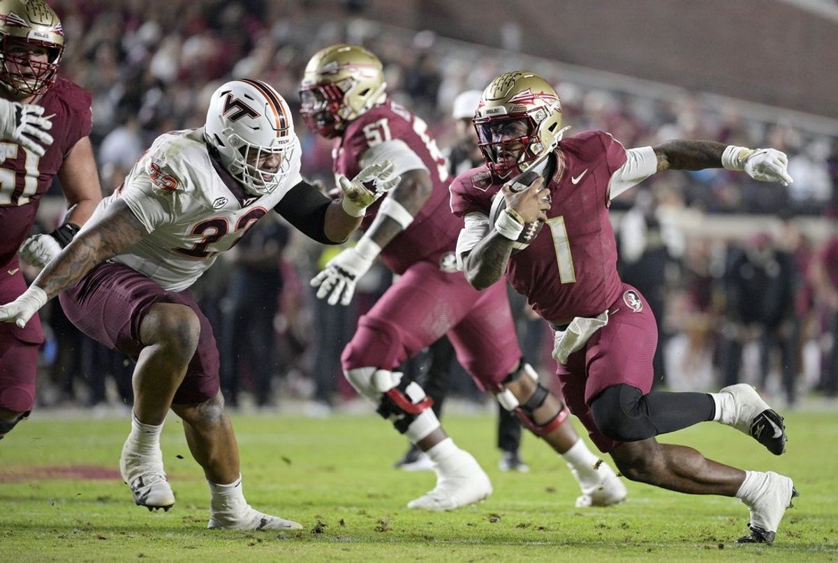 Nov 15, 2025; Tallahassee, Florida, USA; Florida State Seminoles quarterback Thomas Castellanos (1) runs the ball past Virginia Tech Hokies defensive lineman Kelvin Gilliam Jr. (22) during the first half at Doak S. Campbell Stadium. Mandatory Credit: Melina Myers-Imagn Images