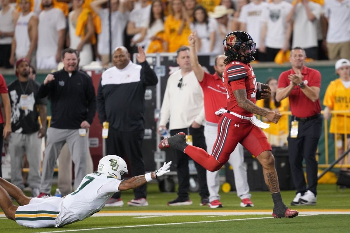 Nov 15, 2025; Waco, Texas, USA;  Utah Utes quarterback Byrd Ficklin (15) carries the ball for a 67-yard touchdown ahead of Baylor Bears safety Tyler Turner (17) during the first half at McLane Stadium. Mandatory Credit: Chris Jones-Imagn Images