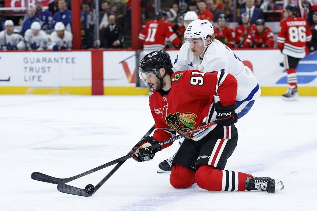 Nov 15, 2025; Chicago, Illinois, USA; Toronto Maple Leafs center Bobby McMann (74) battles for the puck with Chicago Blackhawks center Frank Nazar (91) during the first period at United Center. Mandatory Credit: Kamil Krzaczynski-Imagn Images