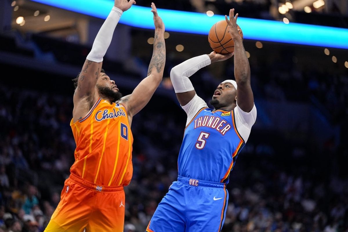 Nov 15, 2025; Charlotte, North Carolina, USA; Oklahoma City Thunder guard Luguentz Dort (5) shoots defended by Charlotte Hornets forward Miles Bridges (0) during the second half at Spectrum Center. Mandatory Credit: Jim Dedmon-Imagn Images