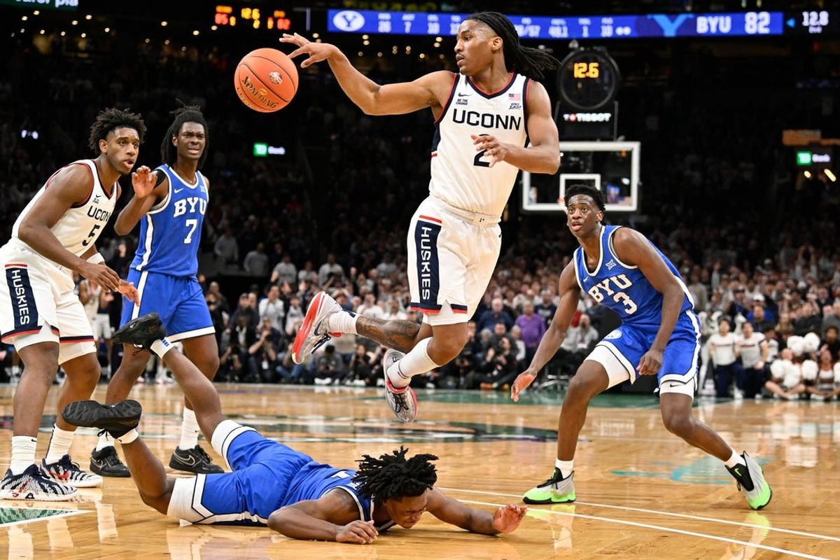 Nov 15, 2025; Boston, Massachusetts, USA; UConn Huskies guard Silas Demary Jr. (2) passes the ball turned over by BYU Cougars guard Robert Wright III (1) during the second half at TD Garden. Mandatory Credit: Eric Canha-Imagn Images