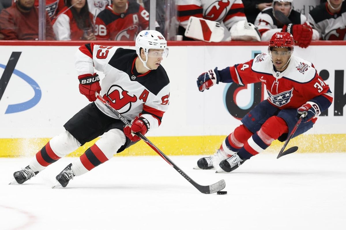 Nov 15, 2025; Washington, District of Columbia, USA; New Jersey Devils left wing Jesper Bratt (63) skates with the puck against as Washington Capitals right wing Justin Sourdif (34) chases during the third period at Capital One Arena. Mandatory Credit: Geoff Burke-Imagn Images