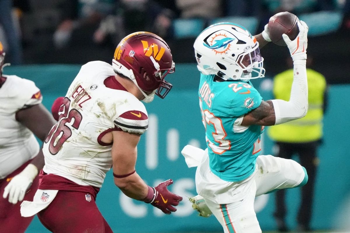 Nov 16, 2025; Madrid, Spain; Miami Dolphins cornerback Jack Jones (23) intercepts a pass intended for Washington Commanders tight end Zach Ertz (86) in overtime during the 2025 NFL Madrid Game at Santiago Bernabeu Stadium. Mandatory Credit: Kirby Lee-Imagn Images