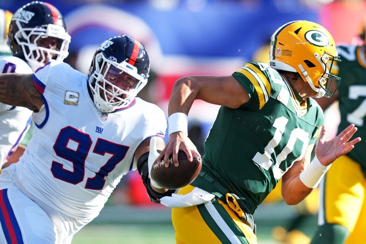 Nov 16, 2025; East Rutherford, New Jersey, USA; Green Bay Packers quarterback Jordan Love (10) scrambles away from New York Giants defensive tackle Dexter Lawrence II (97) during the first quarter at MetLife Stadium. Mandatory Credit: Robert Deutsch-Imagn Images