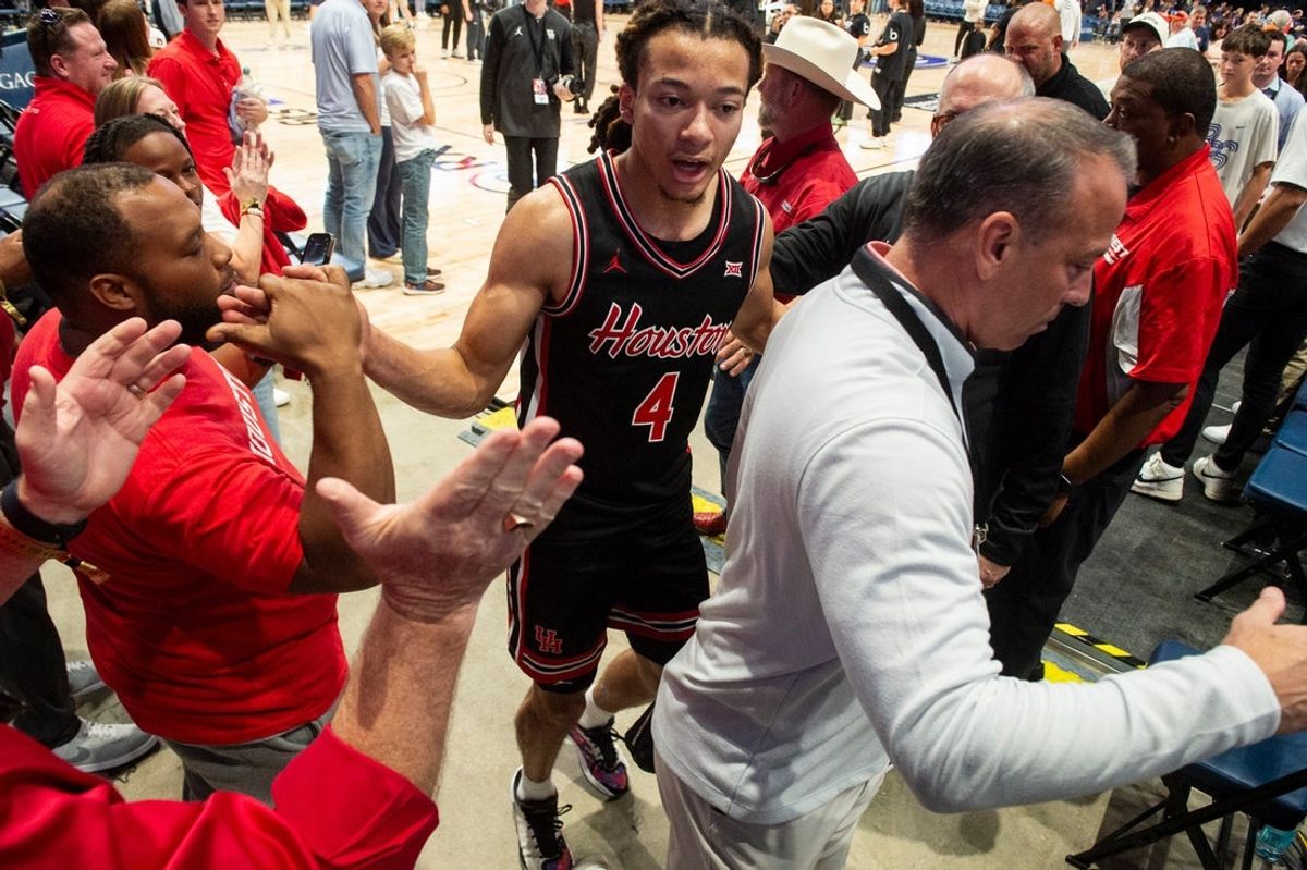 Houston Cougars guard Kingston Flemings (4) celebrates with fans as he walks off the court as Auburn Tigers take on the Houston Cougars at Legacy Arena in Birmingham, Ala. on Sunday, Nov. 16, 2025. Houston Cougars defeated Auburn Tigers 73-72.