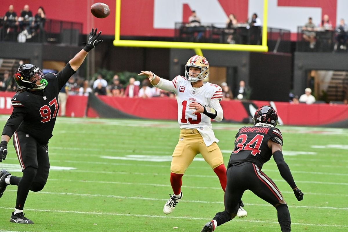Nov 16, 2025; Glendale, Arizona, USA; San Francisco 49ers quarterback Brock Purdy (13) throws the ball while Arizona Cardinals defensive lineman Walter Nolen III (97) defends in the first half at State Farm Stadium. Mandatory Credit: Matt Kartozian-Imagn Images