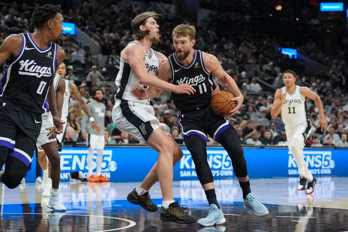 Nov 16, 2025; San Antonio, Texas, USA; Sacramento Kings forward Domantas Sabonis (11) drives in against San Antonio Spurs forward Kelly Olynyk (8) in the second half at Frost Bank Center. Mandatory Credit: Daniel Dunn-Imagn Images