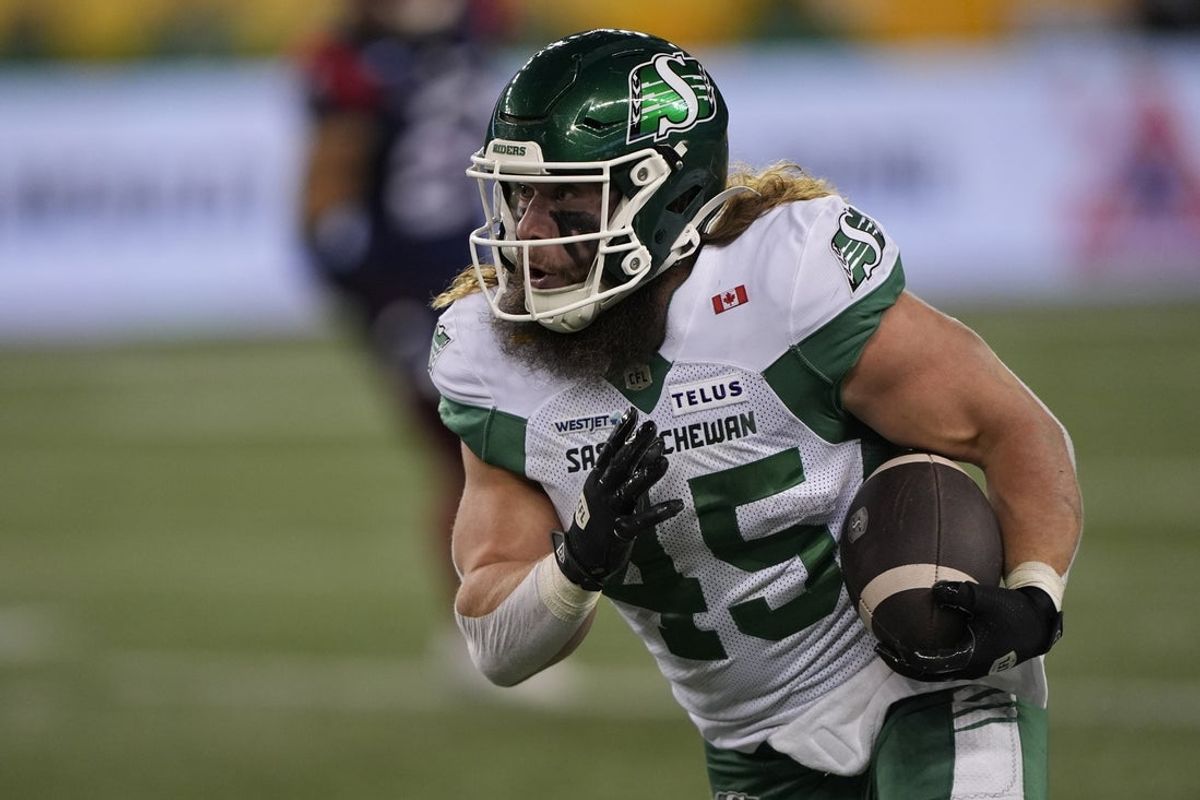 Nov 16, 2025; Winnipeg, Manitoba, Canada;  Saskatchewan Roughriders running back A.J. Ouellette (45) runs the ball during the second quarter against Montreal Alouettes defensive back Najee Murray (12) during the 112th Grey Cup Championship at Princess Auto Stadium. Mandatory Credit: John E. Sokolowski-Imagn Images