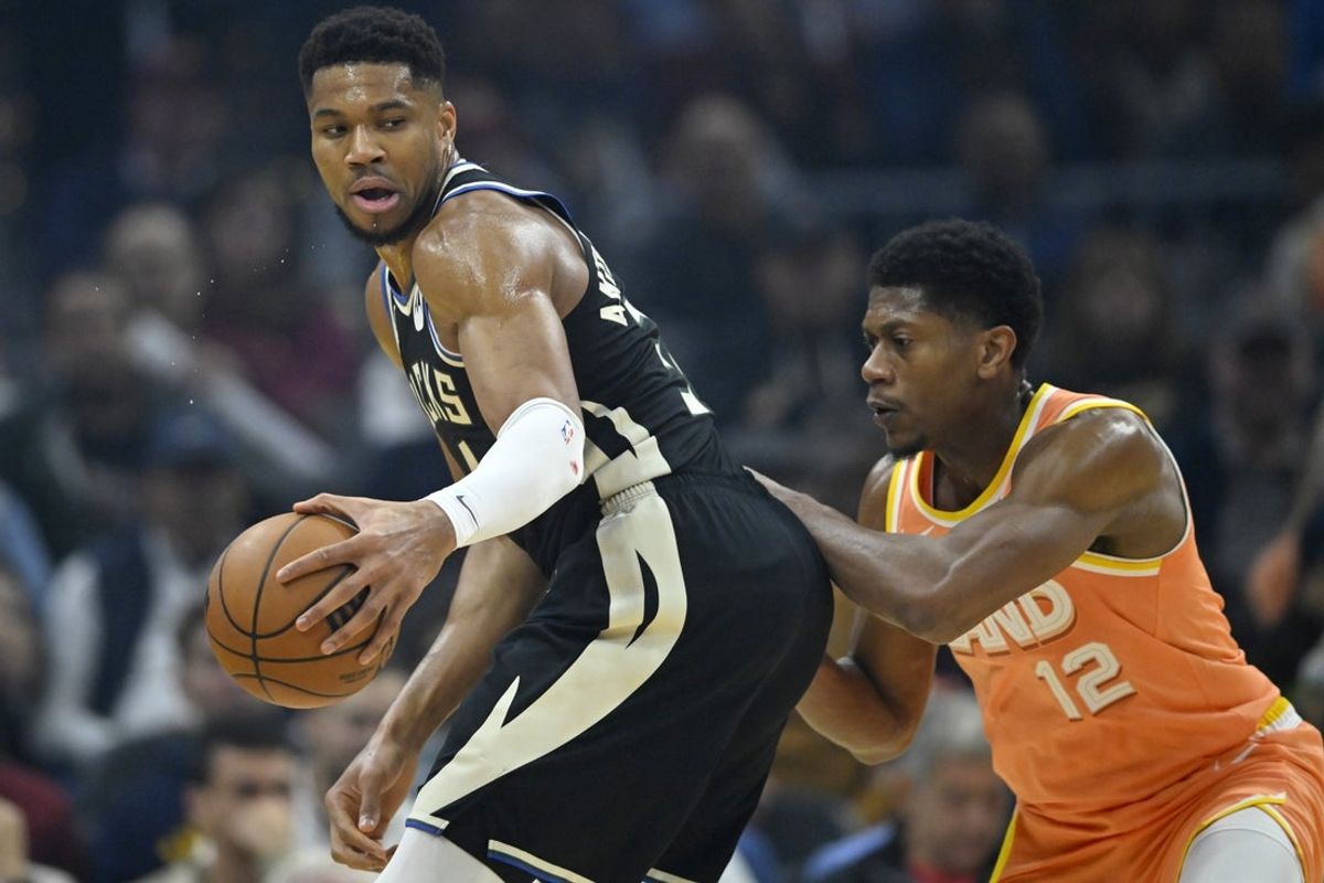 Nov 17, 2025; Cleveland, Ohio, USA; Milwaukee Bucks forward Giannis Antetokounmpo (34) holds the ball beside Cleveland Cavaliers forward De'Andre Hunter (12) in the first quarter at Rocket Arena. Mandatory Credit: David Richard-Imagn Images