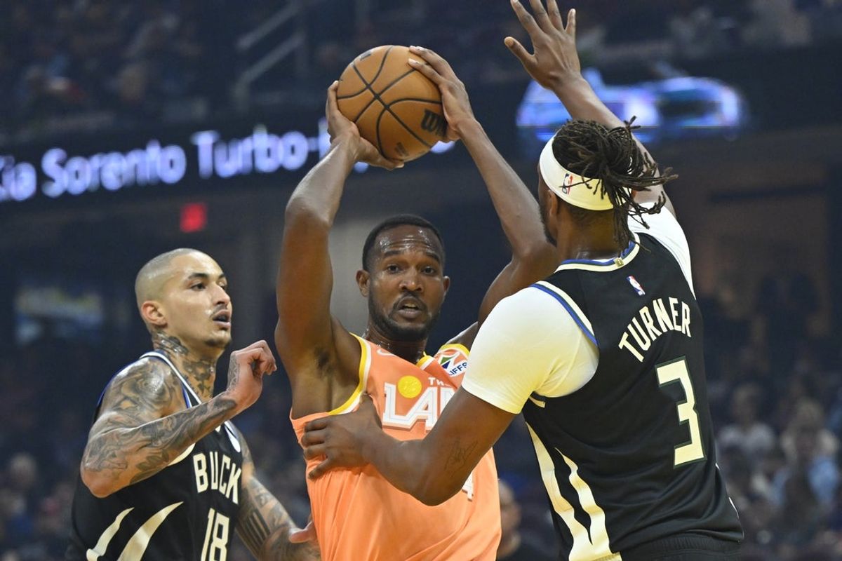 Nov 17, 2025; Cleveland, Ohio, USA; Milwaukee Bucks forward Kyle Kuzma (18) and center Myles Turner (3) defend Cleveland Cavaliers center Evan Mobley (4) in the first quarter at Rocket Arena. Mandatory Credit: David Richard-Imagn Images