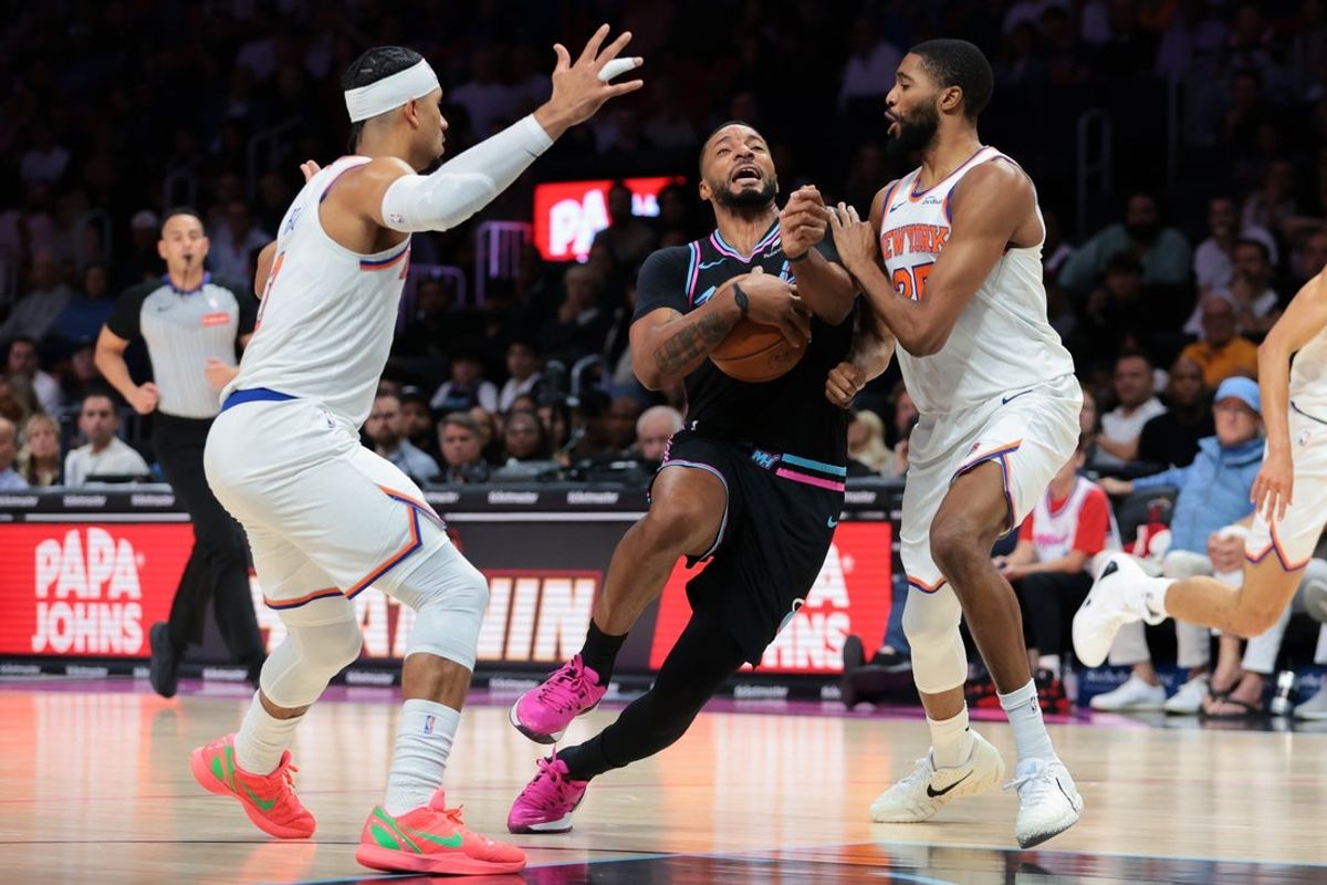 Nov 17, 2025; Miami, Florida, USA; Miami Heat guard Norman Powell (24) drives to the basket against New York Knicks guard Mikal Bridges (25) and guard Josh Hart (3) during the second quarter at Kaseya Center. Mandatory Credit: Sam Navarro-Imagn Images