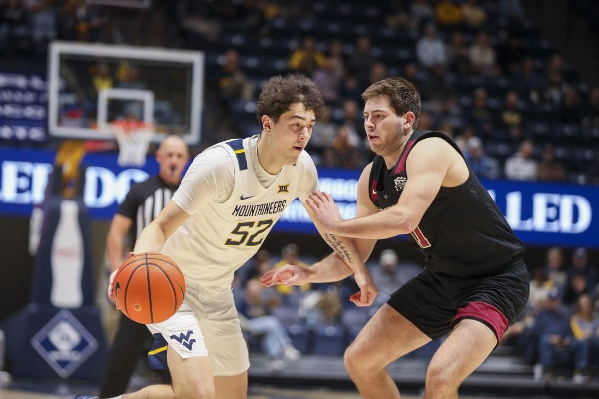 Nov 17, 2025; Morgantown, West Virginia, USA; West Virginia Mountaineers guard Treysen Eaglestaff (52) drives against Lafayette Leopards forward Andrew Phillips (21) during the second half at WVU Coliseum. Mandatory Credit: Ben Queen-Imagn Images