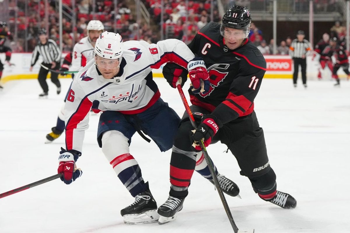 Nov 11, 2025; Raleigh, North Carolina, USA;  Carolina Hurricanes center Jordan Staal (11) and Washington Capitals defenseman Jakob Chychrun (6) battle for the puck during the third period at Lenovo Center. Mandatory Credit: James Guillory-Imagn Images