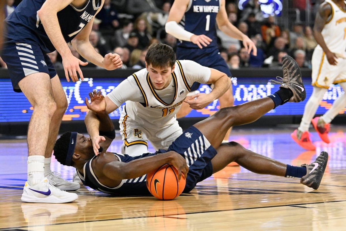Nov 18, 2025; Providence, Rhode Island, USA; New Hampshire Wildcats guard Comeh Emuobor (10) and Providence Friars guard Ryan Mela (11) battle over the loose ball during the first half at Amica Mutual Pavilion. Mandatory Credit: Eric Canha-Imagn Images