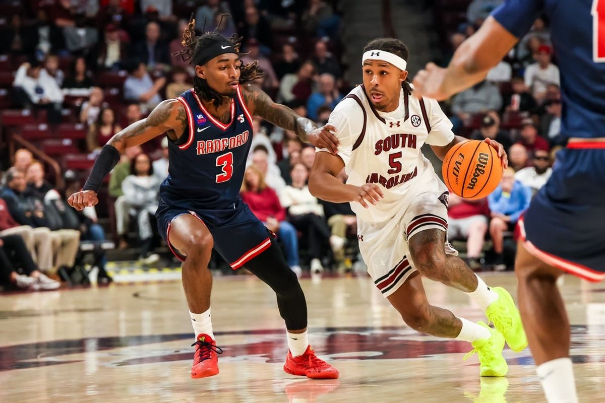 Nov 18, 2025; Columbia, South Carolina, USA; South Carolina Gamecocks guard Meechie Johnson (5) drives around Radford Highlanders guard Jaylon Johnson (3) in the first half at Colonial Life Arena. Mandatory Credit: Jeff Blake-Imagn Images