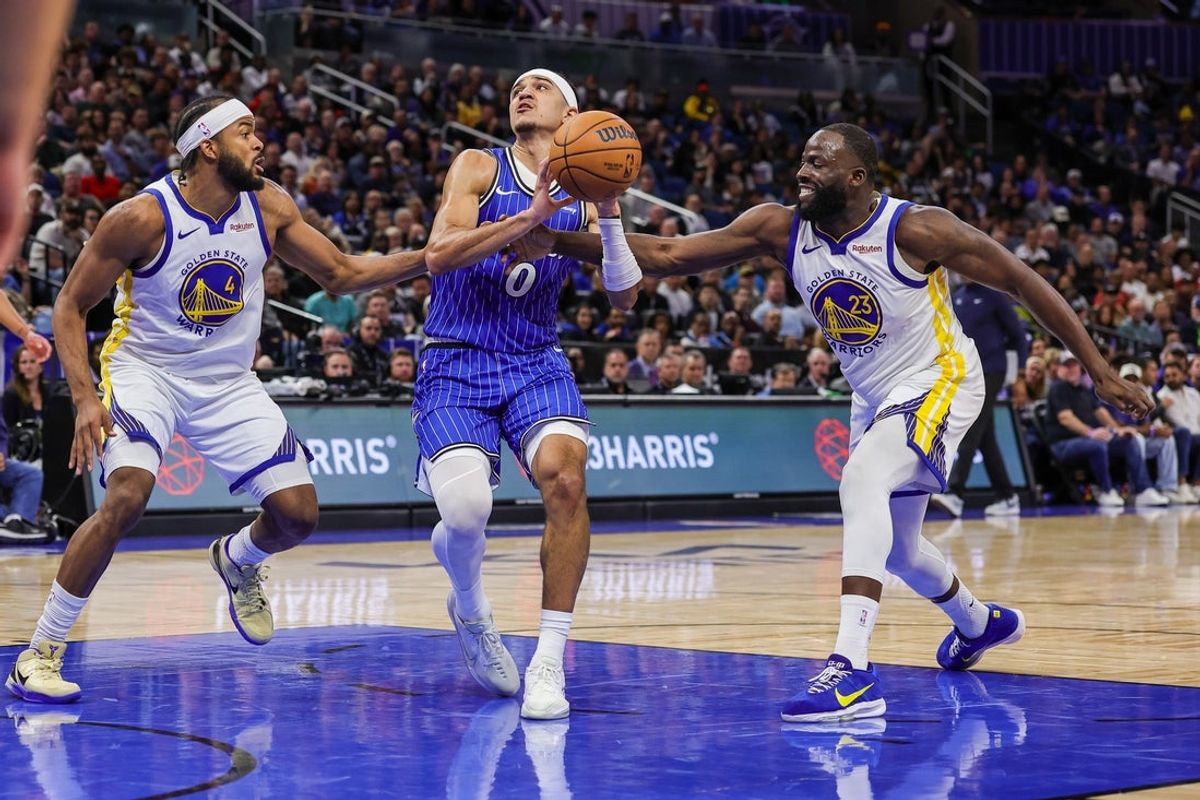 Nov 18, 2025; Orlando, Florida, USA; Orlando Magic guard Anthony Black (0) is fouled by Golden State Warriors forward Draymond Green (23) during the second quarter at Kia Center. Mandatory Credit: Mike Watters-Imagn Images