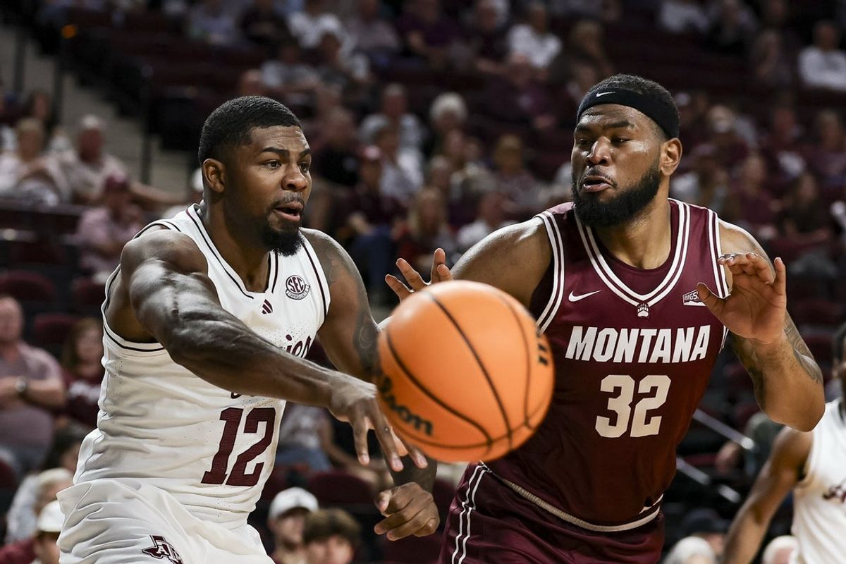 Nov 18, 2025; College Station, Texas, USA; Texas A&M Aggies forward Rashaun Agee (12) passes the ball as Montana Grizzlies forward Te'Jon Sawyer (32) defends during the first half at Reed Arena. Mandatory Credit: Maria Lysaker-Imagn Images