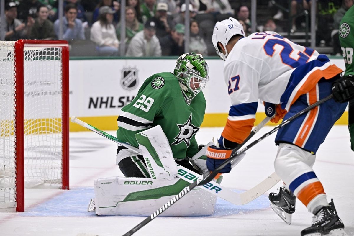 Nov 18, 2025; Dallas, Texas, USA; Dallas Stars goaltender Jake Oettinger (29) makes a save in front of New York Islanders left wing Anders Lee (27) during the first period at the American Airlines Center. Mandatory Credit: Jerome Miron-Imagn Images