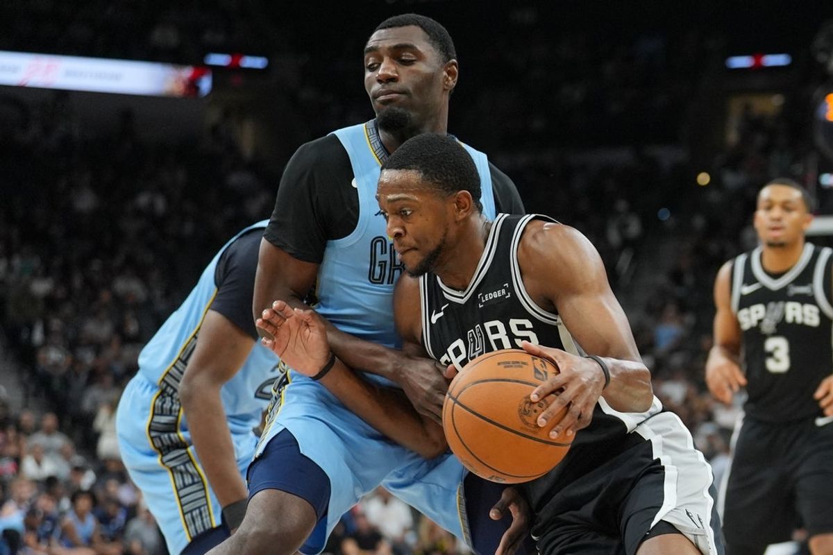 Nov 18, 2025; San Antonio, Texas, USA;  San Antonio Spurs guard De'Aaron Fox (4) dribbles against Memphis Grizzlies guard Vince Williams Jr. (5) in the first half at Frost Bank Center. Mandatory Credit: Daniel Dunn-Imagn Images