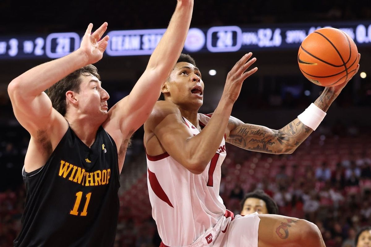 Nov 18, 2025; Fayetteville, Arkansas, USA; Arkansas Razorbacks guard Meleek Thomas (1) drive to the basket against Winthrop Eagles guard Kody Clouet (11) during the first half at Bud Walton Arena. Mandatory Credit: Nelson Chenault-Imagn Images
