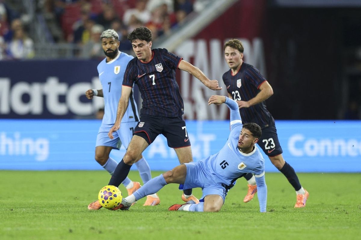 Nov 18, 2025; Tampa, Florida, USA; United States midfielder Gio Reyna (7) and Uruguay midfielder Emiliano Martinez (15) battle for the ball in the second half during an international friendly at Raymond James Stadium. Mandatory Credit: Nathan Ray Seebeck-Imagn Images