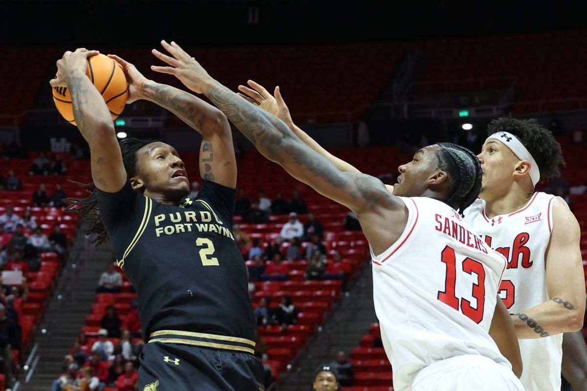 Nov 18, 2025; Salt Lake City, Utah, USA; Purdue Fort Wayne Mastodons guard Mikale Stevenson (2) goes up against Utah Utes forward Kendyl Sanders (13) during the first half at Jon M. Huntsman Center. Mandatory Credit: Rob Gray-Imagn Images