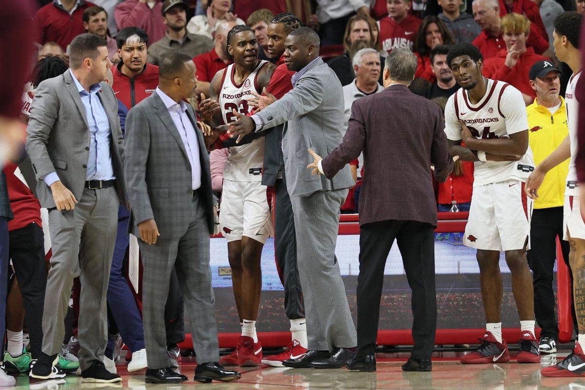 Nov 18, 2025; Fayetteville, Arkansas, USA; Arkansas Razorbacks forward Nick Pringle (23) is moved to the bench after an altercation as wing Billy Richmond III (24) talks to head coach John Calipari during the second half at Bud Walton Arena. Arkansas won 84-83. Mandatory Credit: Nelson Chenault-Imagn Images