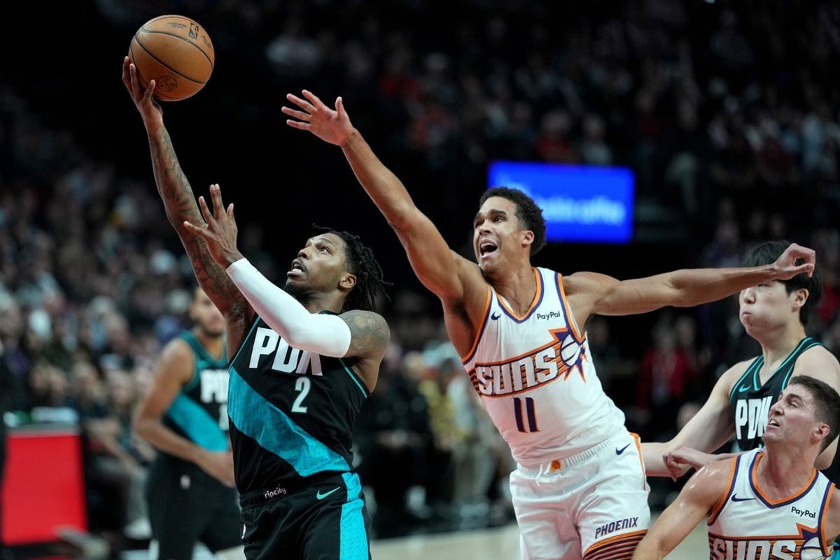 Nov 18, 2025; Portland, Oregon, USA; Portland Trail Blazers guard Caleb Love (2) drives to the basket past Phoenix Suns forward Oso Ighodaro (11) during the first half at Moda Center. Mandatory Credit: Soobum Im-Imagn Images