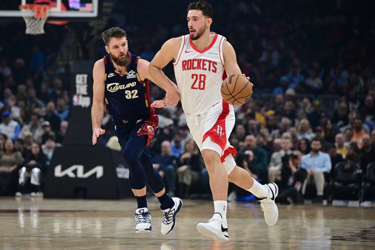 Nov 19, 2025; Cleveland, Ohio, USA; Houston Rockets center Alperen Sengun (28) dribbles ahead of Cleveland Cavaliers forward Dean Wade (32) during the first half at Rocket Arena. Mandatory Credit: David Dermer-Imagn Images