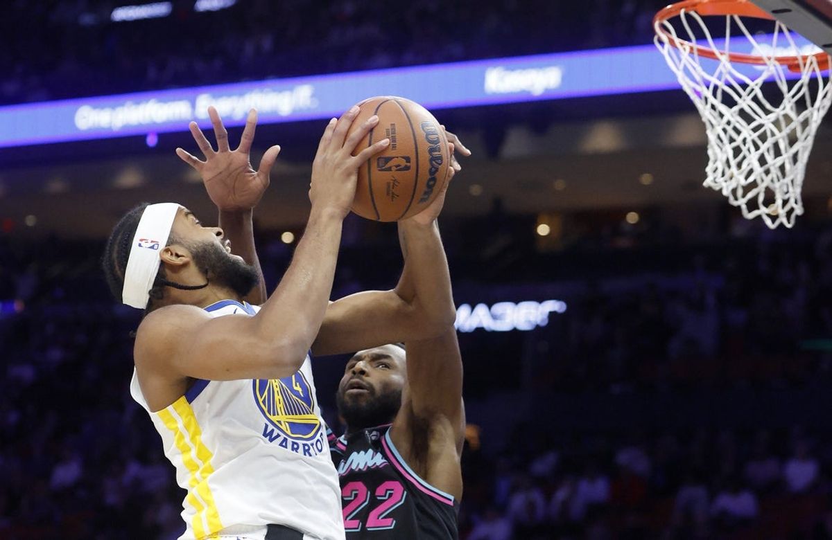 Nov 19, 2025; Miami, Florida, USA; Miami Heat forward Andrew Wiggins (22) defends against Golden State Warriors guard Moses Moody (4) during the first half at Kaseya Center. Mandatory Credit: Rhona Wise-Imagn Images