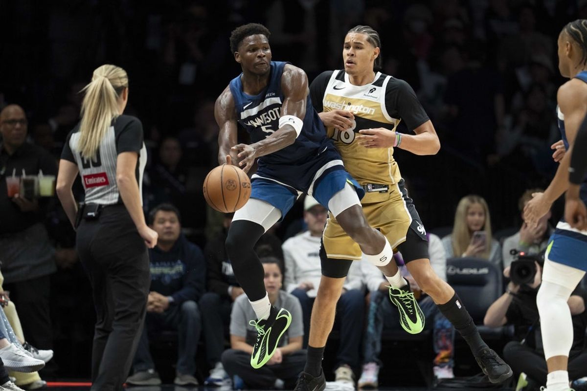Nov 19, 2025; Minneapolis, Minnesota, USA; Minnesota Timberwolves guard Anthony Edwards (5) jumps up to save a ball from going out of bounds in front of Washington Wizards forward Kyshawn George (18) in the first half at Target Center. Mandatory Credit: Jesse Johnson-Imagn Images
