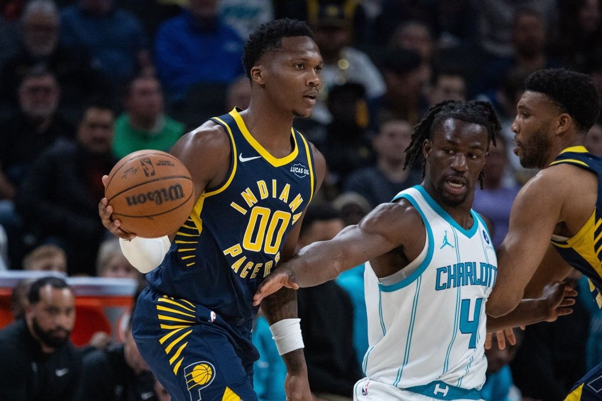 Nov 19, 2025; Indianapolis, Indiana, USA; Indiana Pacers guard Bennedict Mathurin (00) passes the ball while  Charlotte Hornets guard Sion James (4) defends in the first half at Gainbridge Fieldhouse. Mandatory Credit: Trevor Ruszkowski-Imagn Images