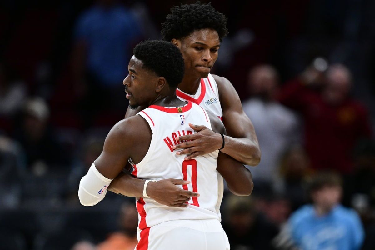 Nov 19, 2025; Cleveland, Ohio, USA; Houston Rockets guard Amen Thompson (1) hugs Houston Rockets guard Aaron Holiday (0) after the Rockets defeated the Cleveland Cavaliers at Rocket Arena. Mandatory Credit: David Dermer-Imagn Images