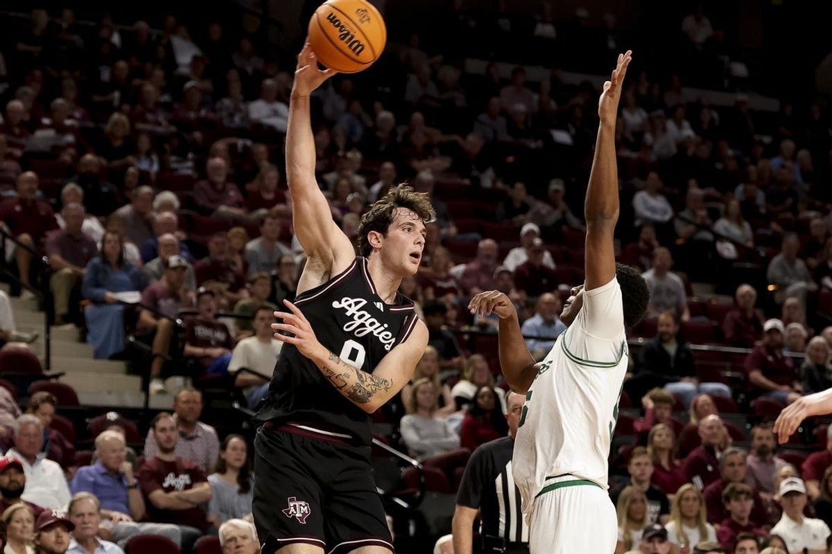 Nov 21, 2025; College Station, Texas, USA; Texas A&M Aggies guard Ruben Dominguez (9) passes the ball over Manhattan Jaspers guard Erik Oliver-Bush (5) during the first half at Reed Arena. Mandatory Credit: Maria Lysaker-Imagn Images