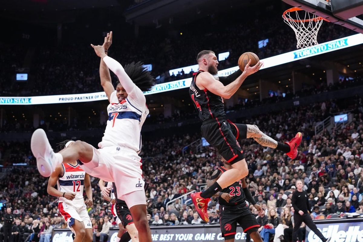 Nov 21, 2025; Toronto, Ontario, CAN; Sandro Mamukelashvili (54) of the Toronto Raptors drives to the basket against Bub Carrington (7) of the Washington Wizards during the second half at Scotiabank Arena. Mandatory Credit: Kevin Sousa-Imagn Images