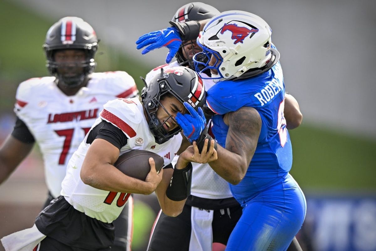 Nov 22, 2025; Dallas, Texas, USA; Louisville Cardinals quarterback Deuce Adams (13) attempts to elude the tackle of SMU Mustangs defensive end Cameron Robertson (9) during the first half at Gerald J. Ford Stadium. Mandatory Credit: Jerome Miron-Imagn Images