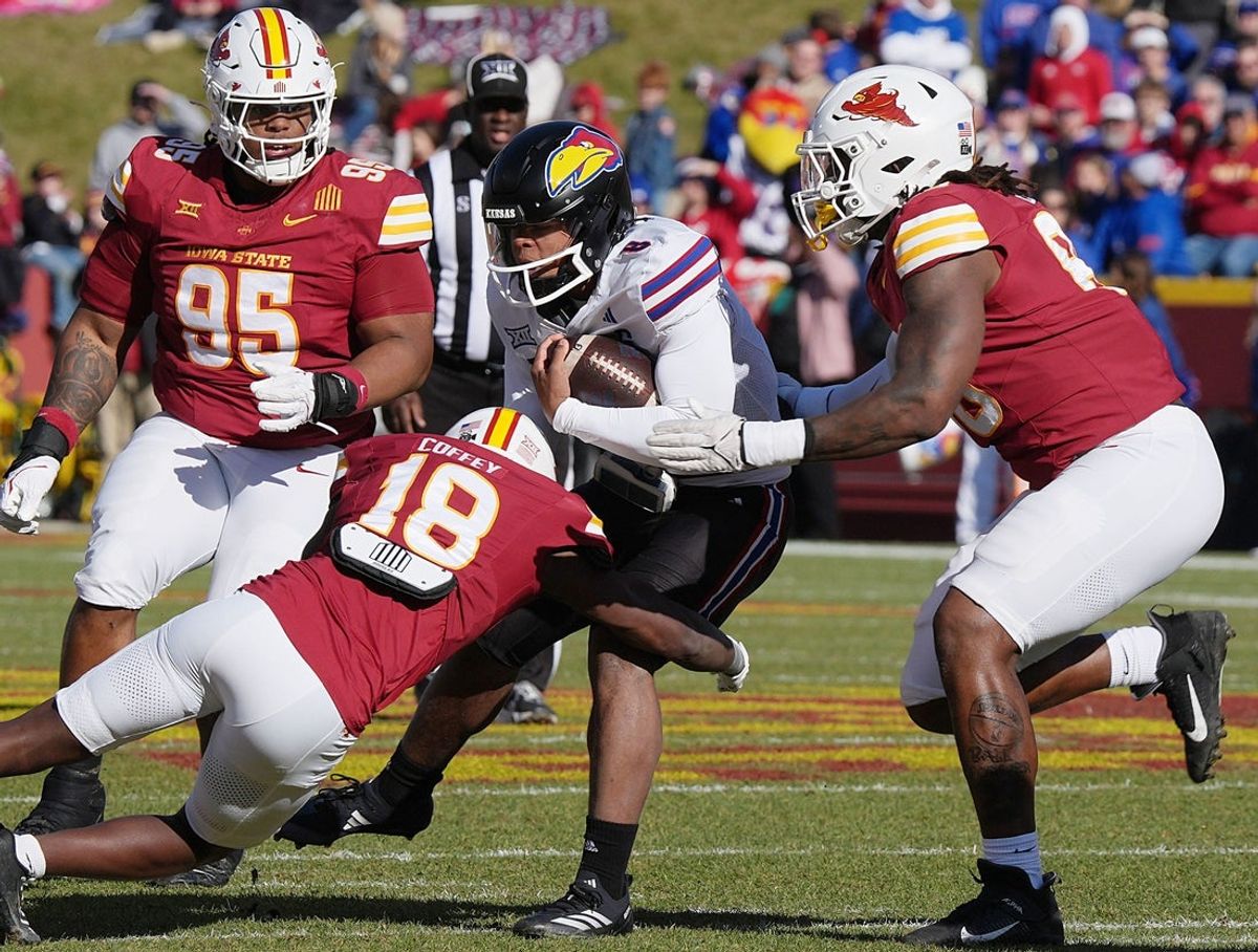 Iowa State Cyclones' defensive back David Coffey (18), defensive line Ikenna Ezeogu (88) and defensive line Domonique Orange (95) takes down Kansas Jayhawks quarterback Isaiah Marshall (8) during the first quarter in the senior day on Nov. 22, 2025, at Jack Trice Stadium in Ames, Iowa